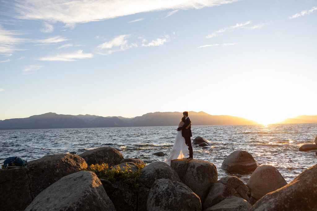 sweet couple hugging on large rocks during their lake tahoe elopement
