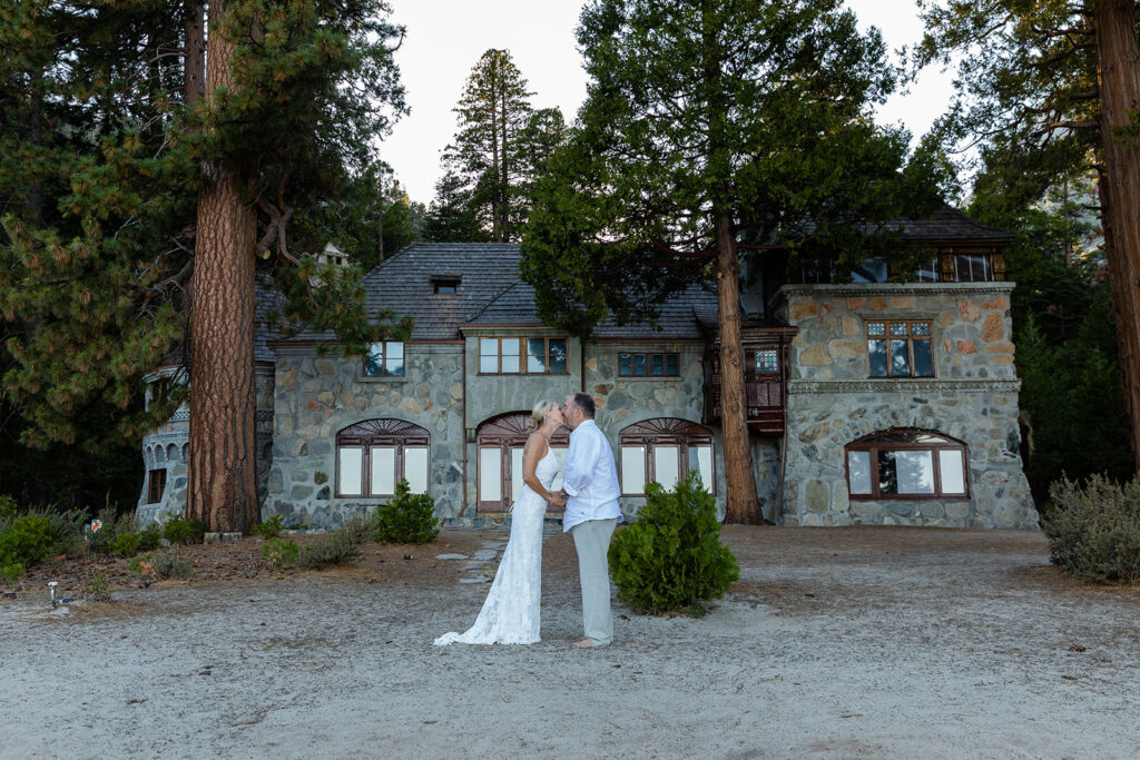 an elopement couple kissing with a rustic stone building in the backdrop