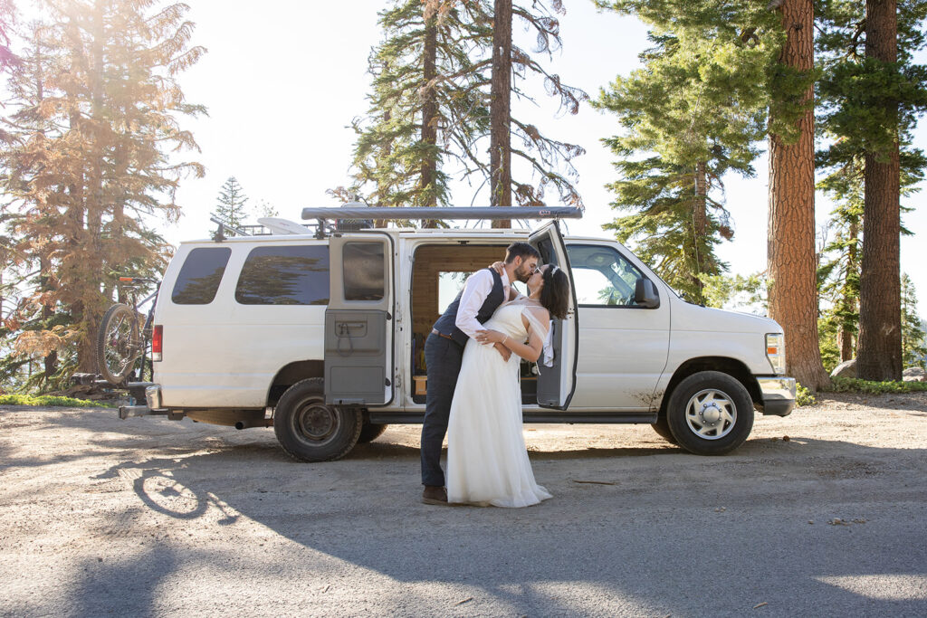 bride and groom cutting and eating their elopement cake in their camper van