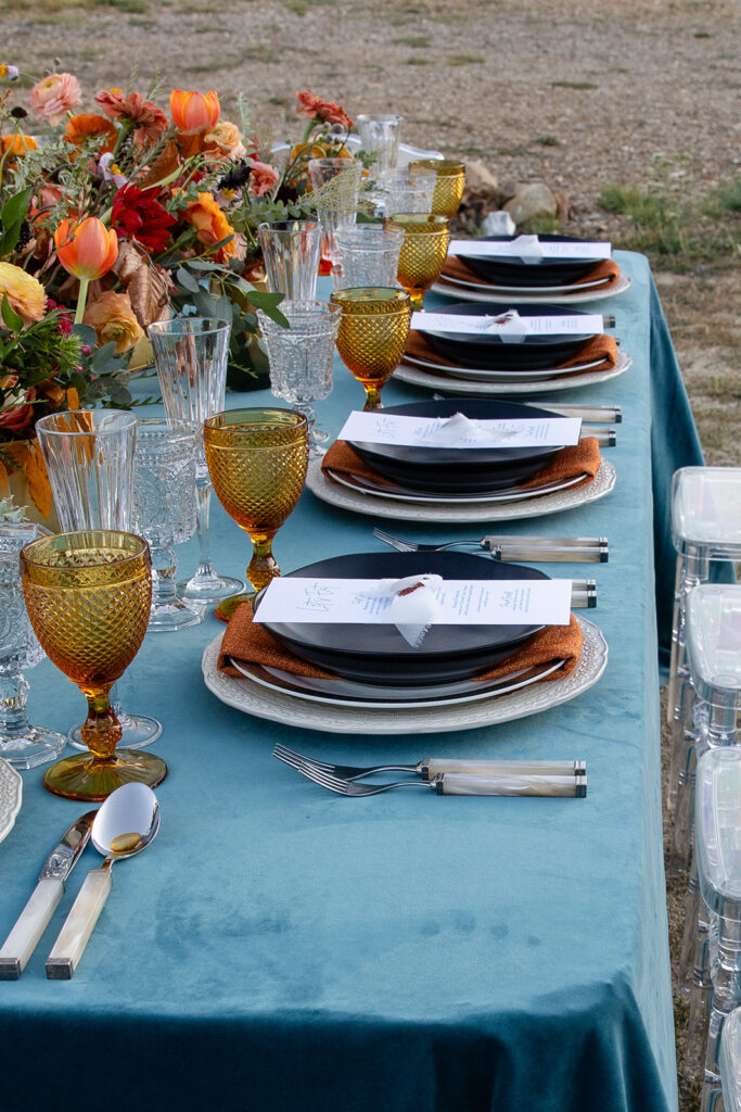 Side view of the wedding table setup with bold florals and vintage glassware