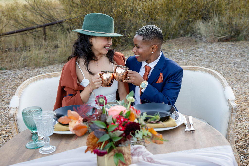 sweet lgbtq couple sitting at their sweethearts table during their Olympic Valley Stables micro wedding