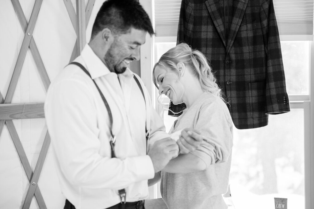 bride and groom helping each other get ready inside the cozy yurt in Lake Tahoe