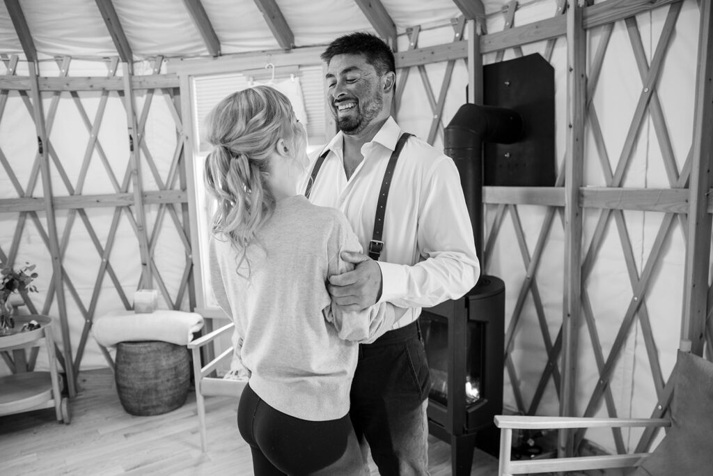 bride and groom helping each other get ready inside the cozy yurt in Lake Tahoe