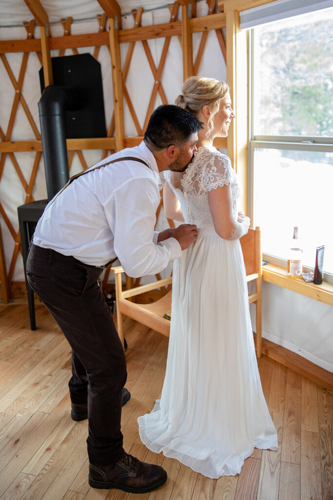 bride and groom helping each other get ready inside the cozy yurt in Lake Tahoe