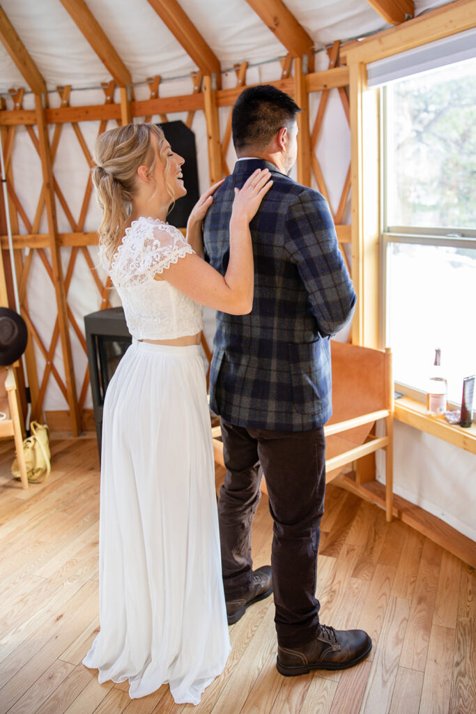 bride and groom helping each other get ready inside the cozy yurt in Lake Tahoe