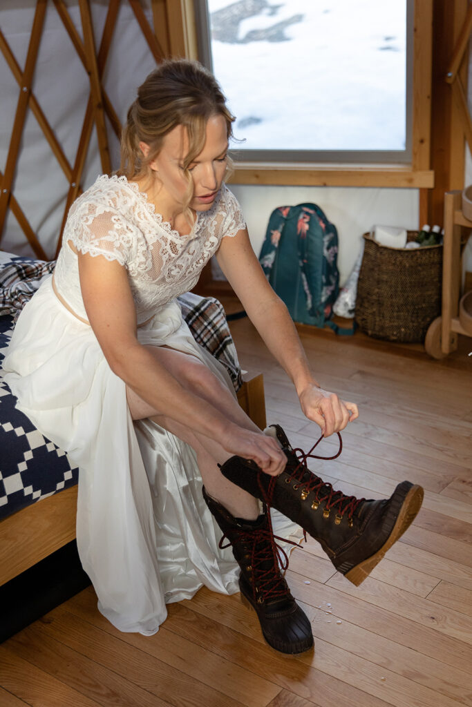bride putting on the boots for their winter elopement in lake tahoe