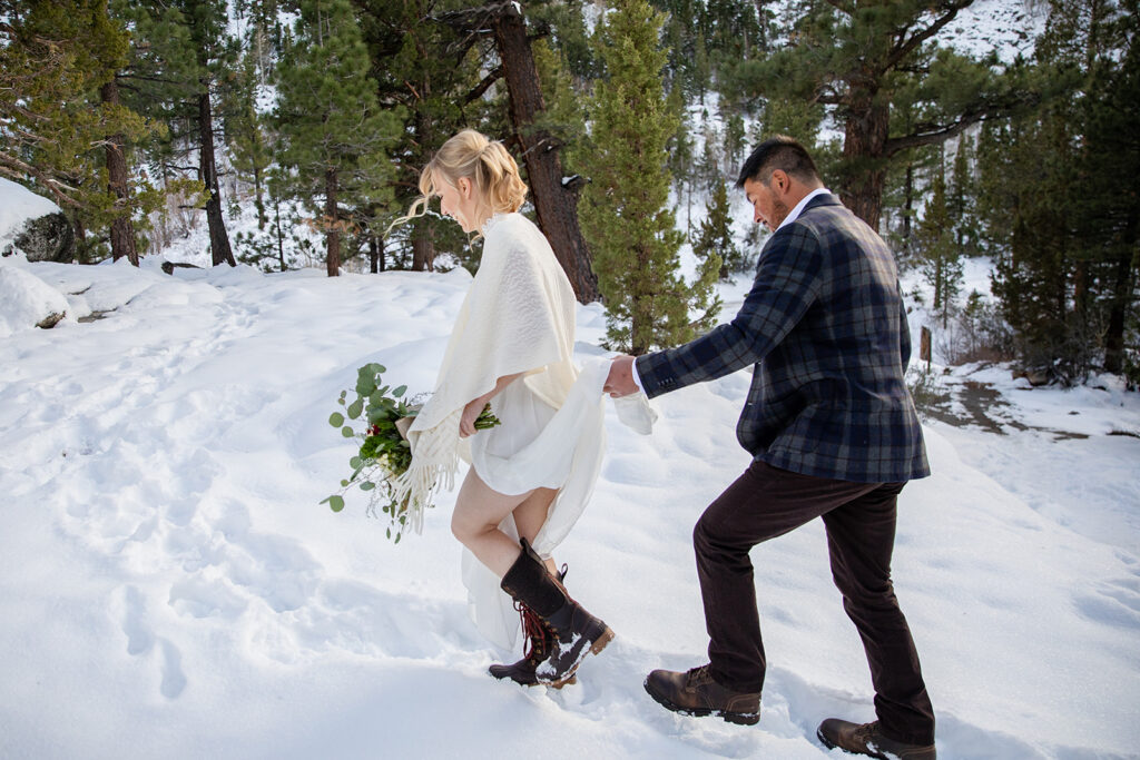 bride and groom hiking through the snow towards their Lake Tahoe winter elopement ceremony location