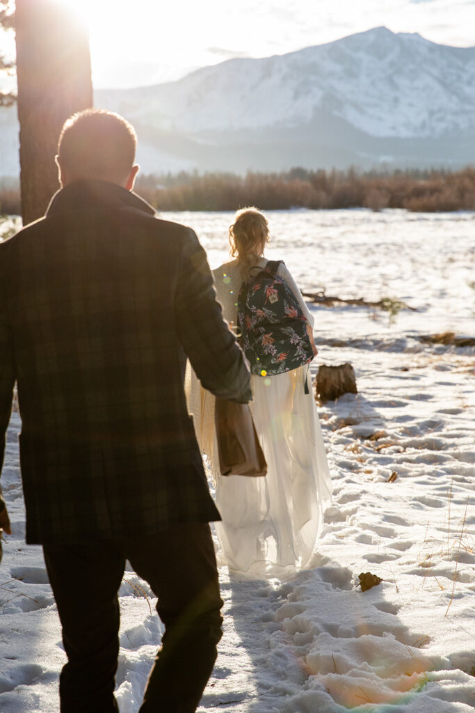 bride and groom hiking through the snow towards their Lake Tahoe winter elopement ceremony location