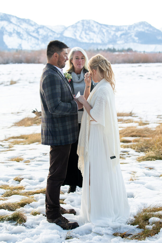 The couple exchanges vows during their intimate winter elopement ceremony in Lake Tahoe