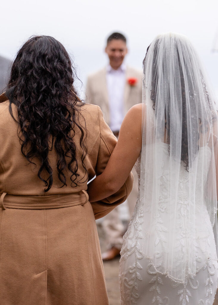 bride and mom walking down the aisle
