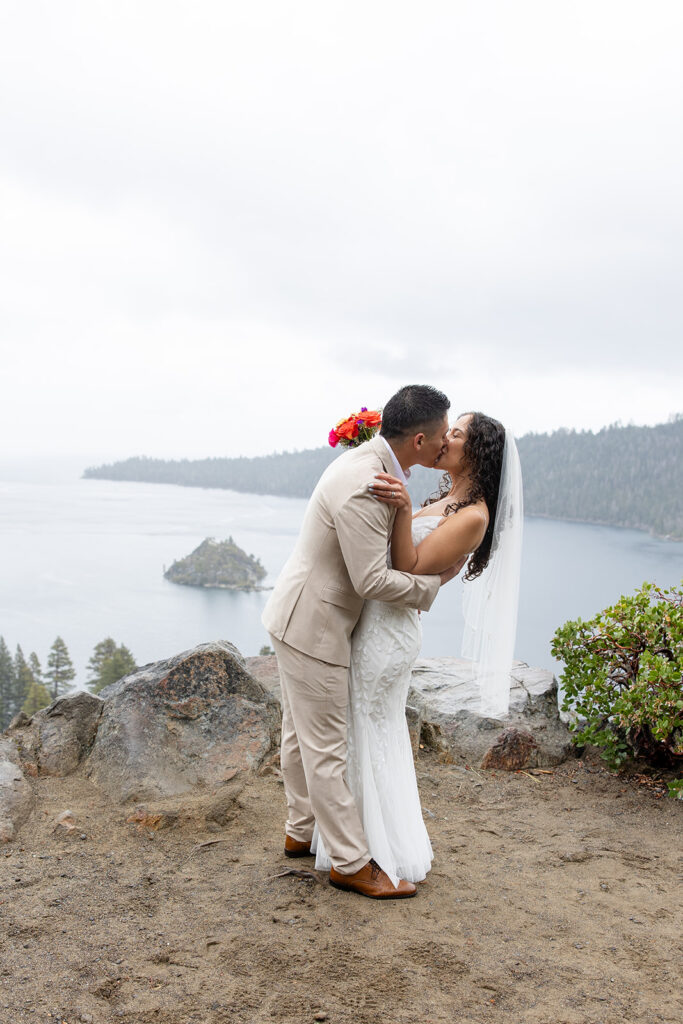 bride and groom kissing during a rainy emerald bay elopement in lake tahoe