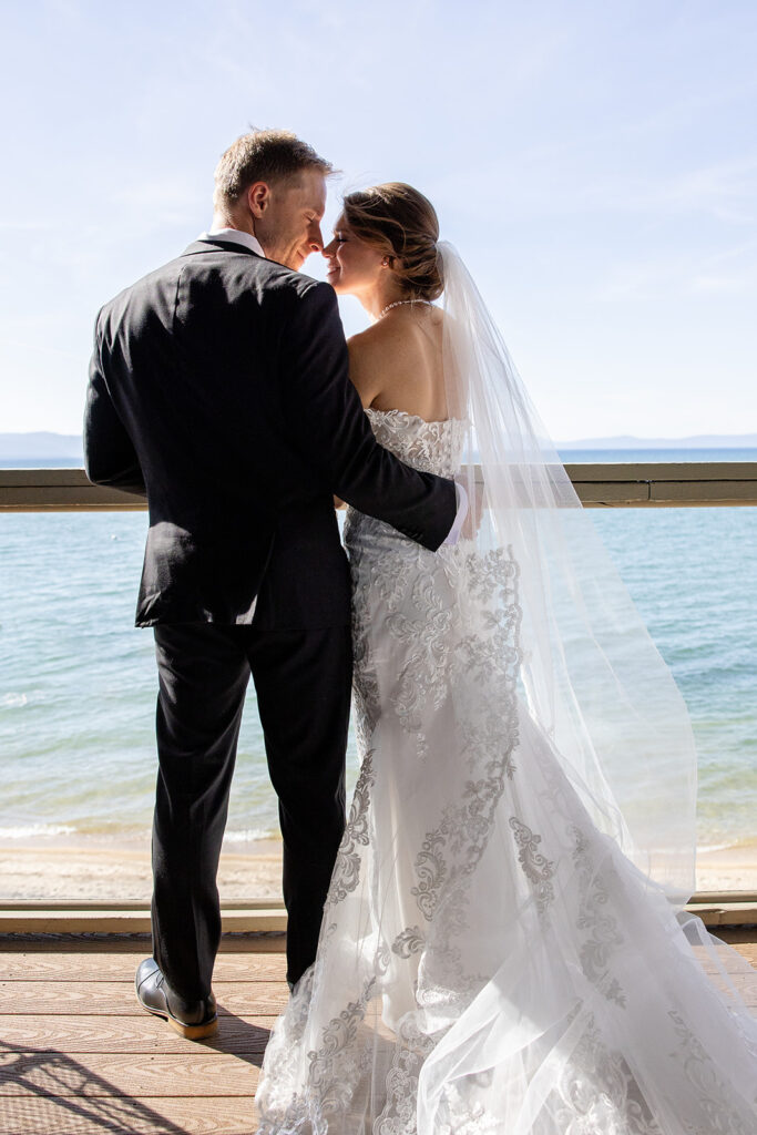 bride and groom standing on the dock overlooking lake tahoe