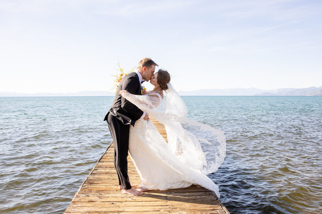 romantic barefoot bride and groom holding each other on the dock at lake tahoe 
