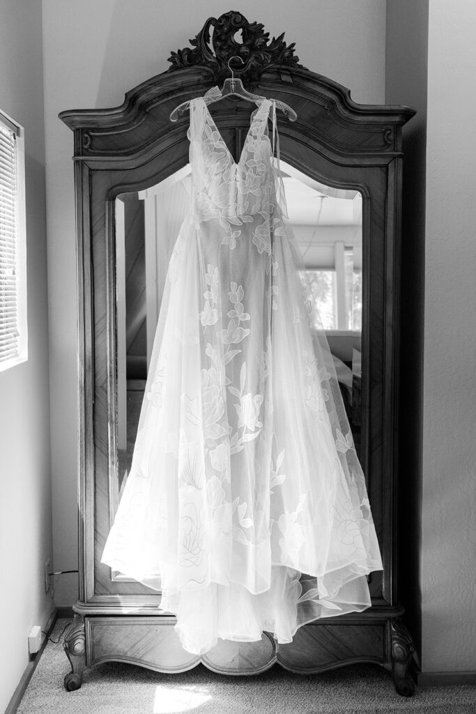 wedding dress hanging on a vintage mirror