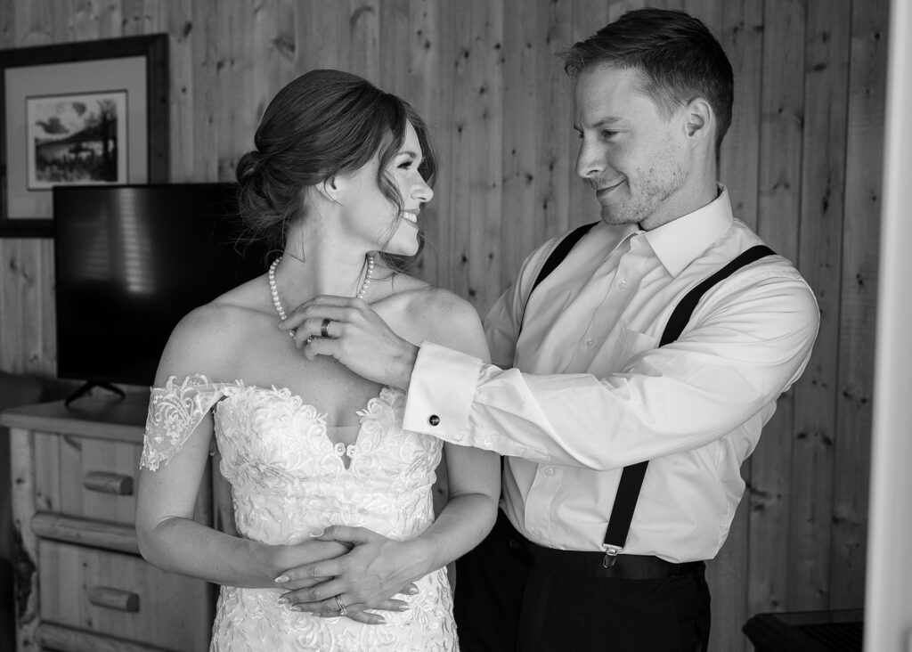 bride and groom helping each other get ready 