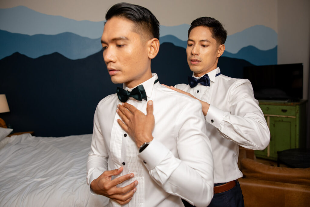grooms helping each other get ready