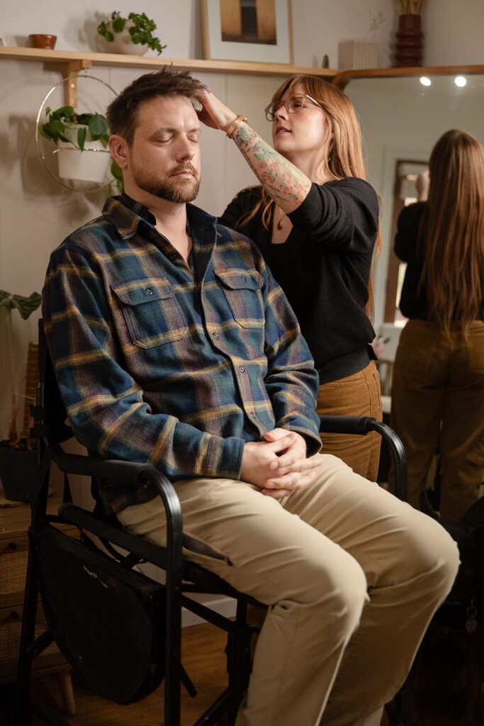 groom getting his hair and make up done ahead of the elopement