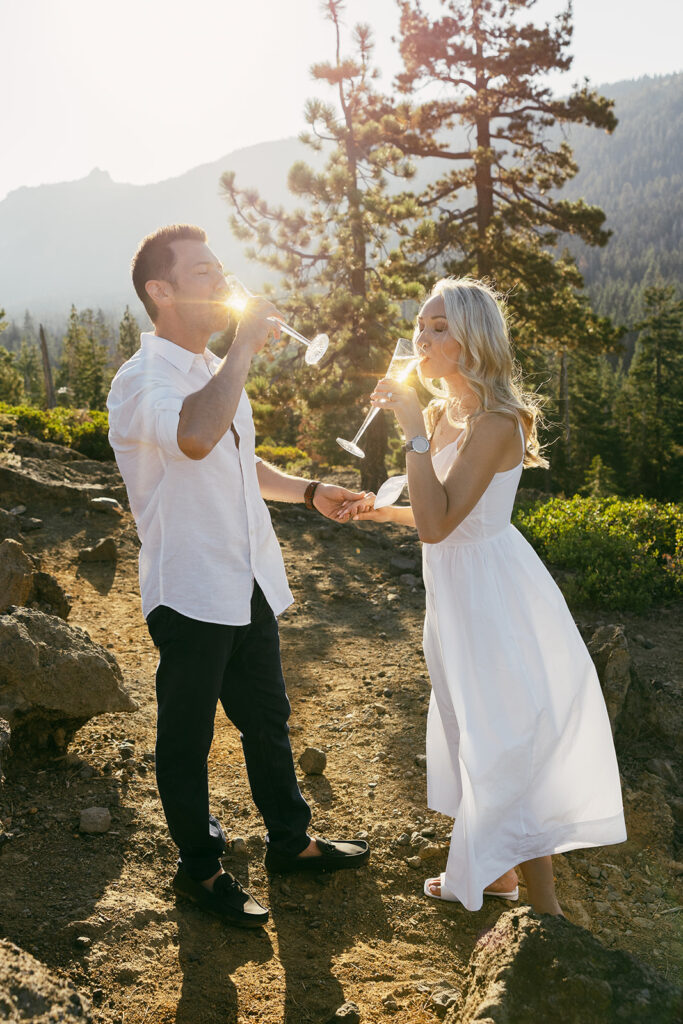 newly engaged couple drinking champagne during their engagement session at eagle rock, lake tahoe