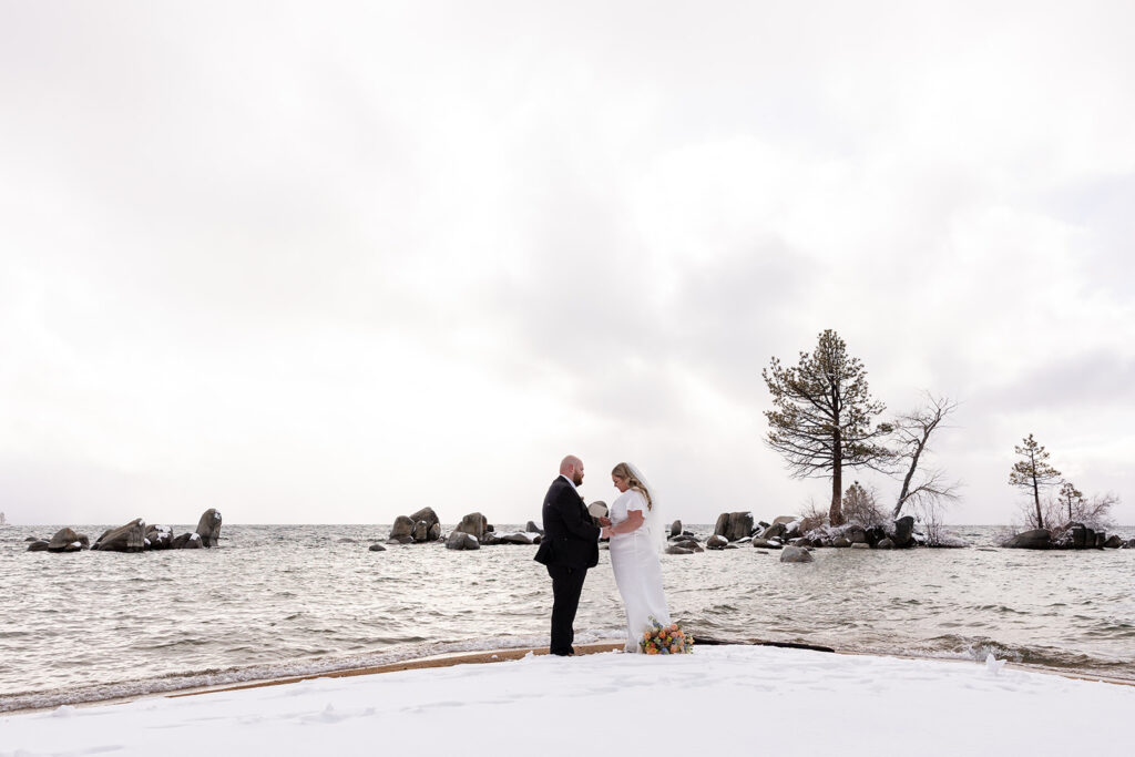 bride and groom exchanging private vows during their snowy spring micro wedding ceremony at lake tahoe 
