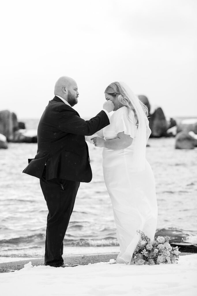 bride and groom exchanging private vows during their snowy spring micro wedding ceremony at lake tahoe 
