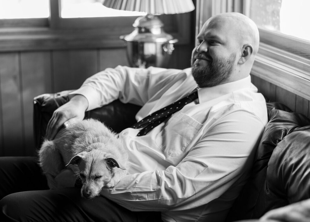 groom sitting with pup in his lap