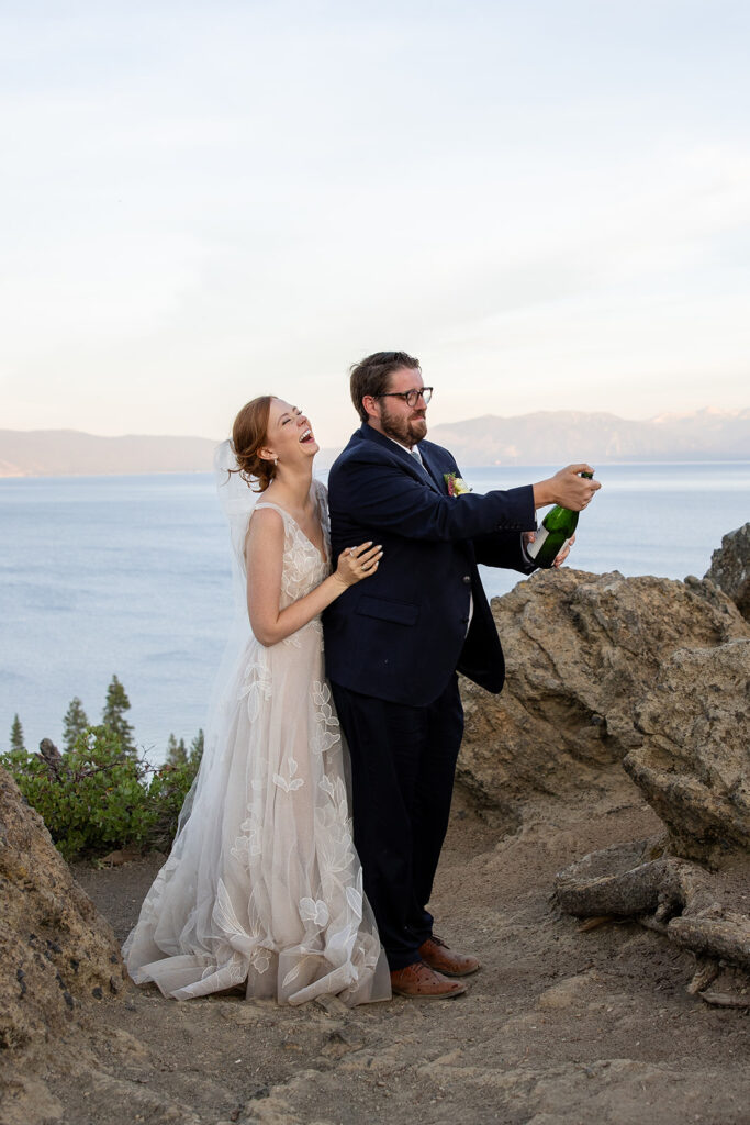 bride and groom popping champagne at a mountain overlook in lake tahoe