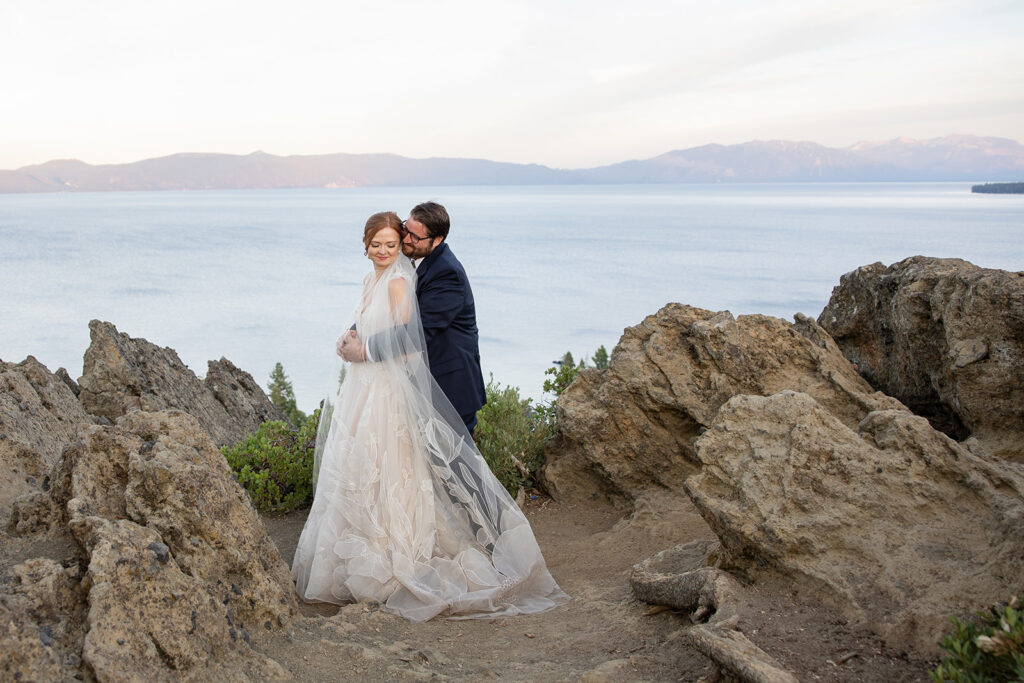 playful bride and groom at a lake tahoe mountain overlook