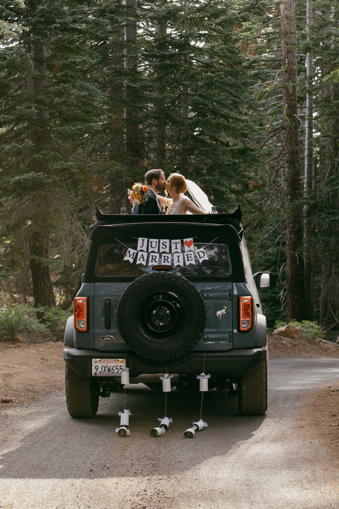bride and groom posing with their jeep during their Lake Tahoe adventure elopement