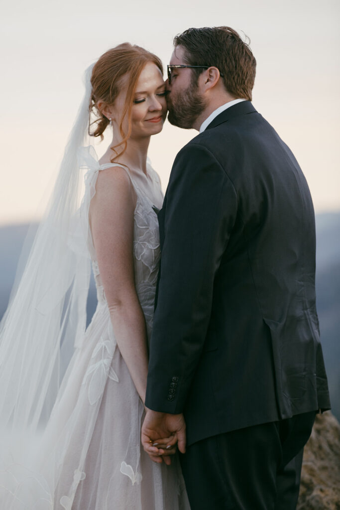 bride and groom hugging on a mountain overlook during their Lake Tahoe adventure elopement