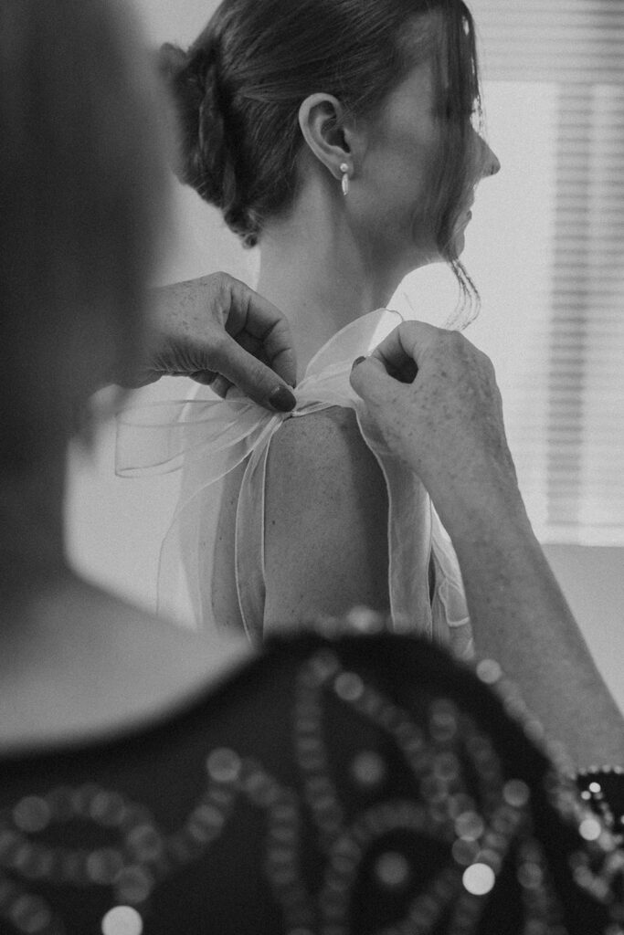 mom helping bride into her dress