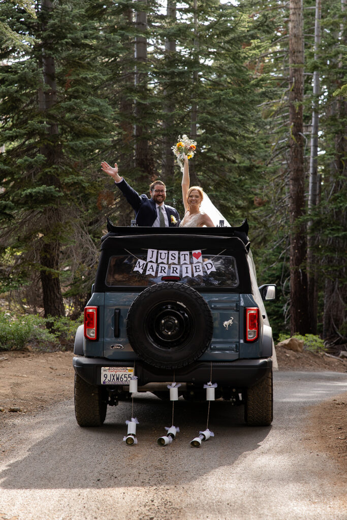 bride and groom posing with their jeep during their Lake Tahoe adventure elopement