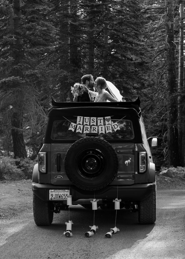 bride and groom posing with their jeep during their Lake Tahoe adventure elopement