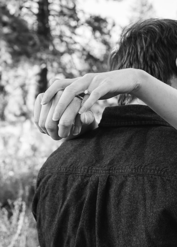 playful couple at a meadow in zephyr cove with lush forest in the background