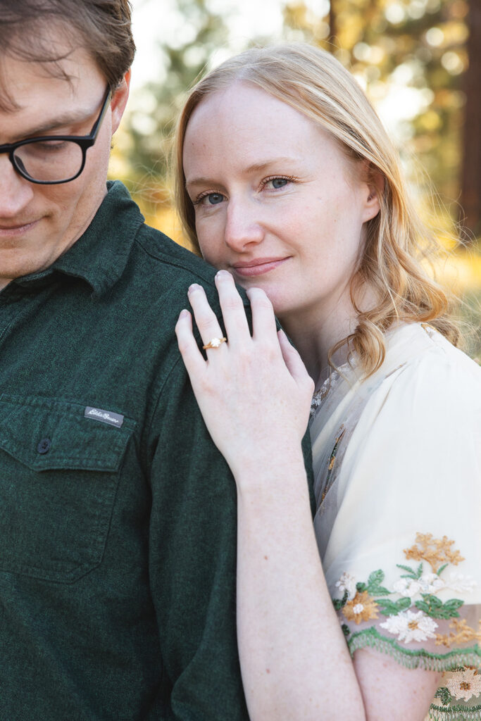 playful couple at a meadow in zephyr cove with lush forest in the background