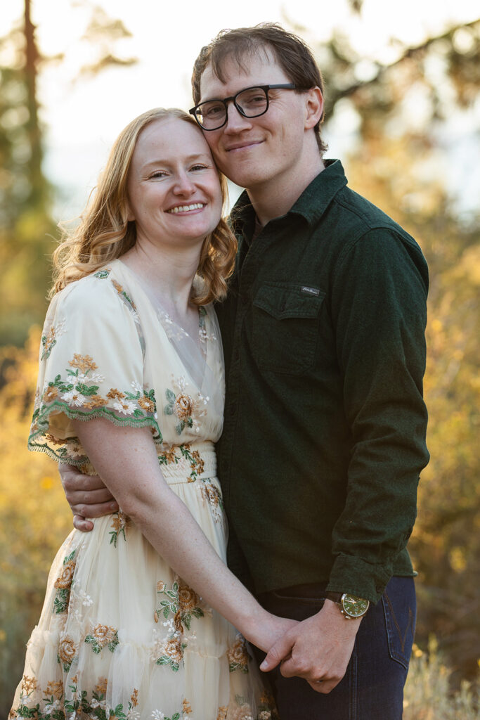 playful couple at a meadow in zephyr cove with lush forest in the background