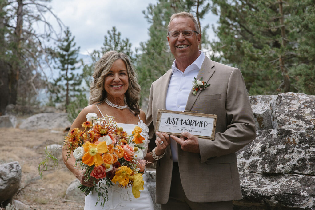bride and groom holding up a just married sign in lake tahoe