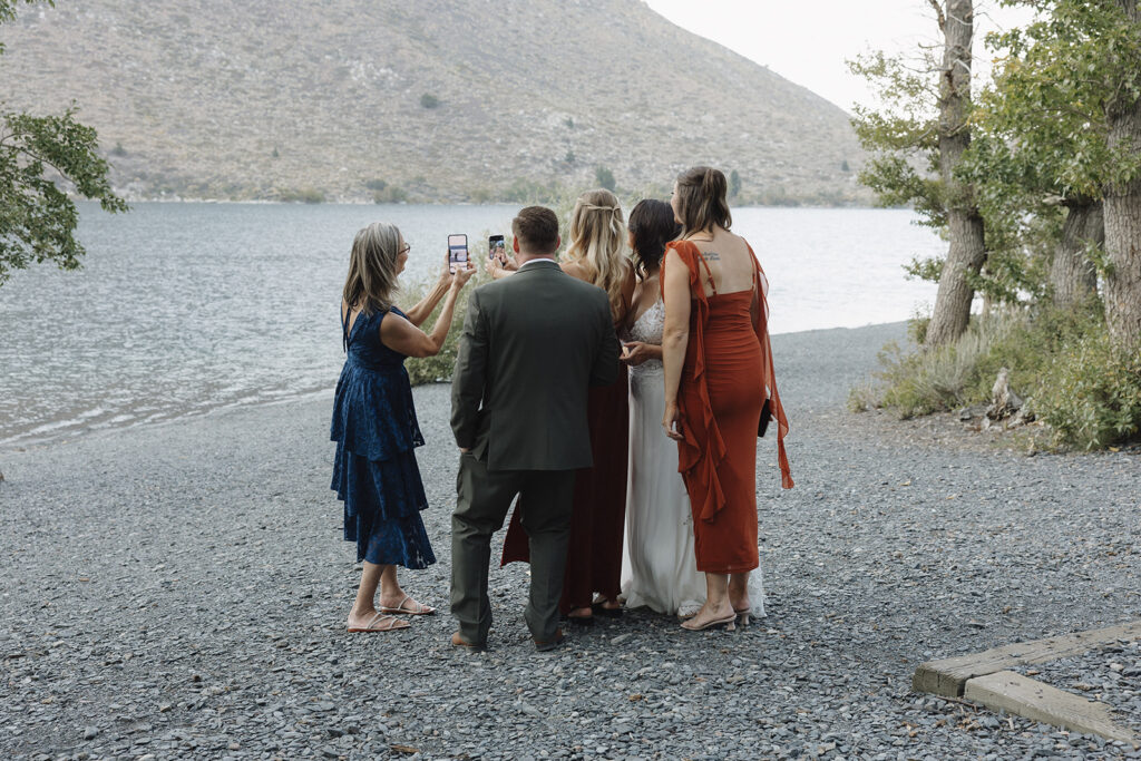 guests taking a selfie with the bride and groom